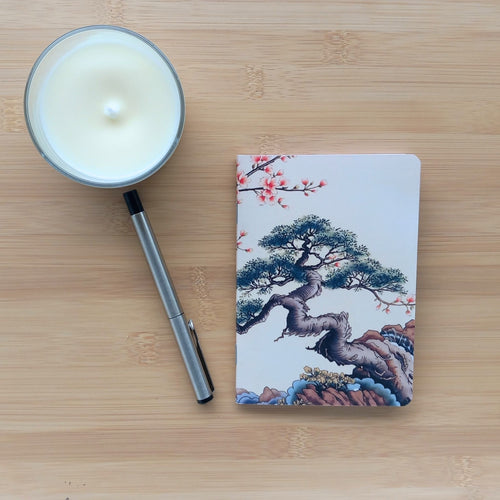 Première de couverture du carnet de notes A6 artisanal, représentant un pin de style bonsaï détaillé sur des rochers et des motifs d'eau.