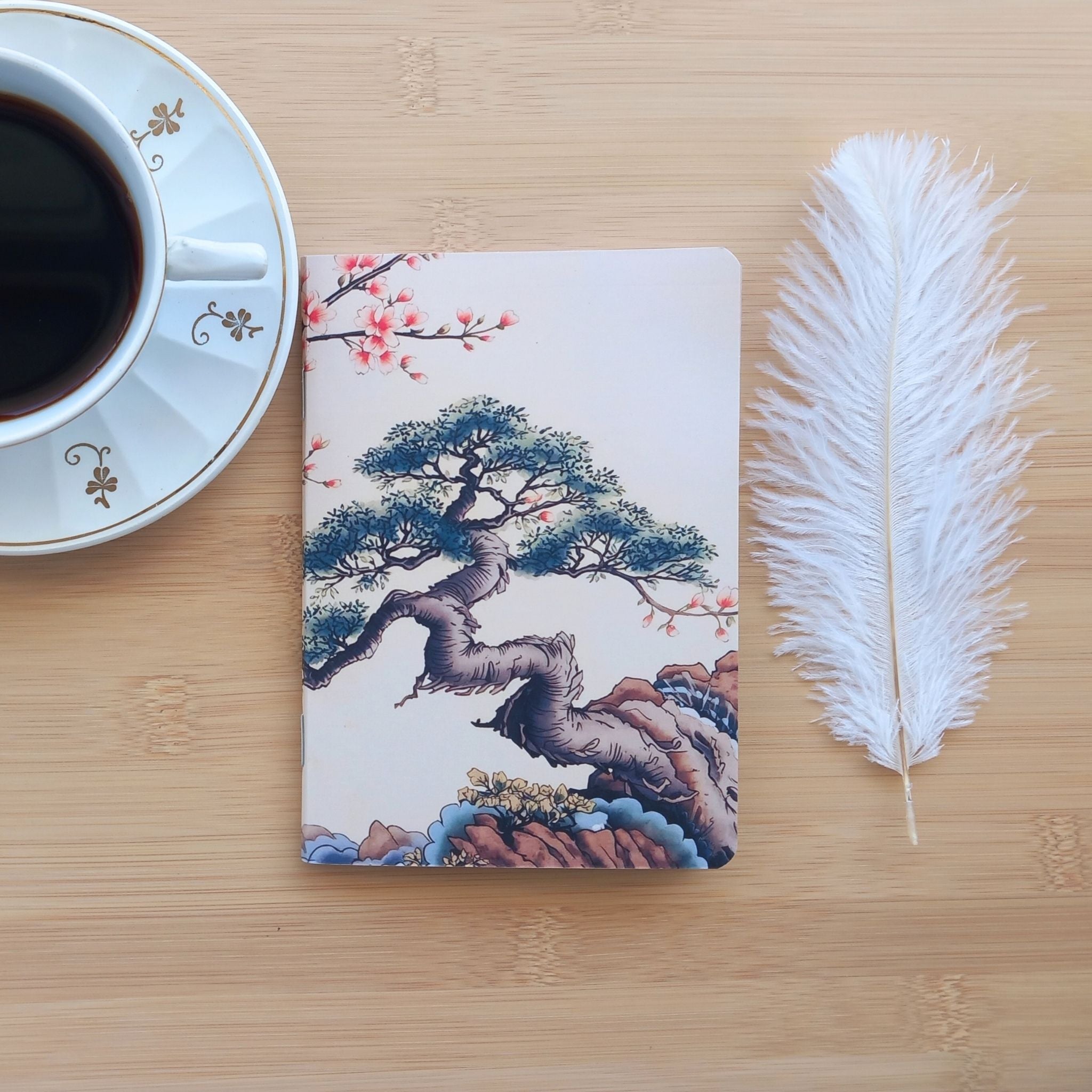 Gros plan sur la couverture avant du carnet "Bonsaï d'Orient", mettant en valeur les détails de l'illustration à l'encre et à l'aquarelle.