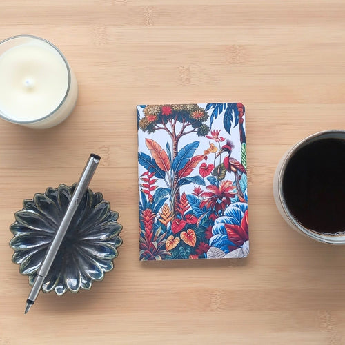 Couverture avant du carnet A6 artisanal, décorée d'une illustration organique mêlant feuilles de monstera, oiseaux à huppe et fleurs de paradis dans des tons sauge et terre de sienne.