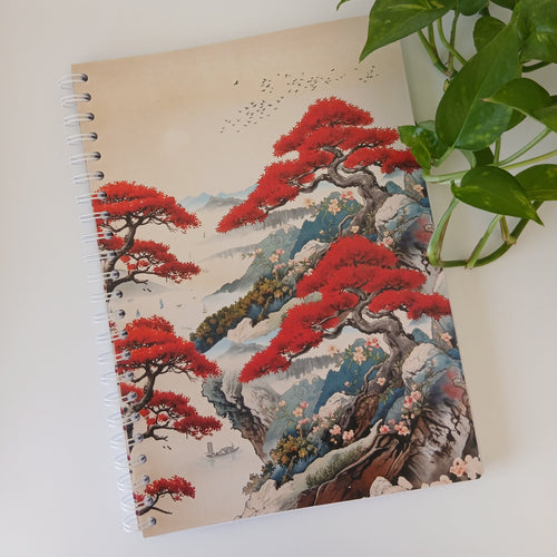 Carnet à spirale A4 fait main "Cimes Vermillon du Levant", couverture souple illustrée d'un paysage de montagnes brumeuses bleutées, de pins tordus au feuillage rouge vermillon, d'un vol d'oiseaux et de jonques au loin, style estampe japonaise Ukiyo-e.